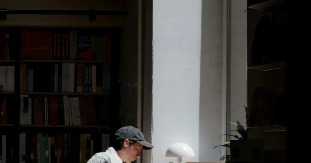 A man sitting quietly at a desk, looking distant and disengaged, Path Community men's support group